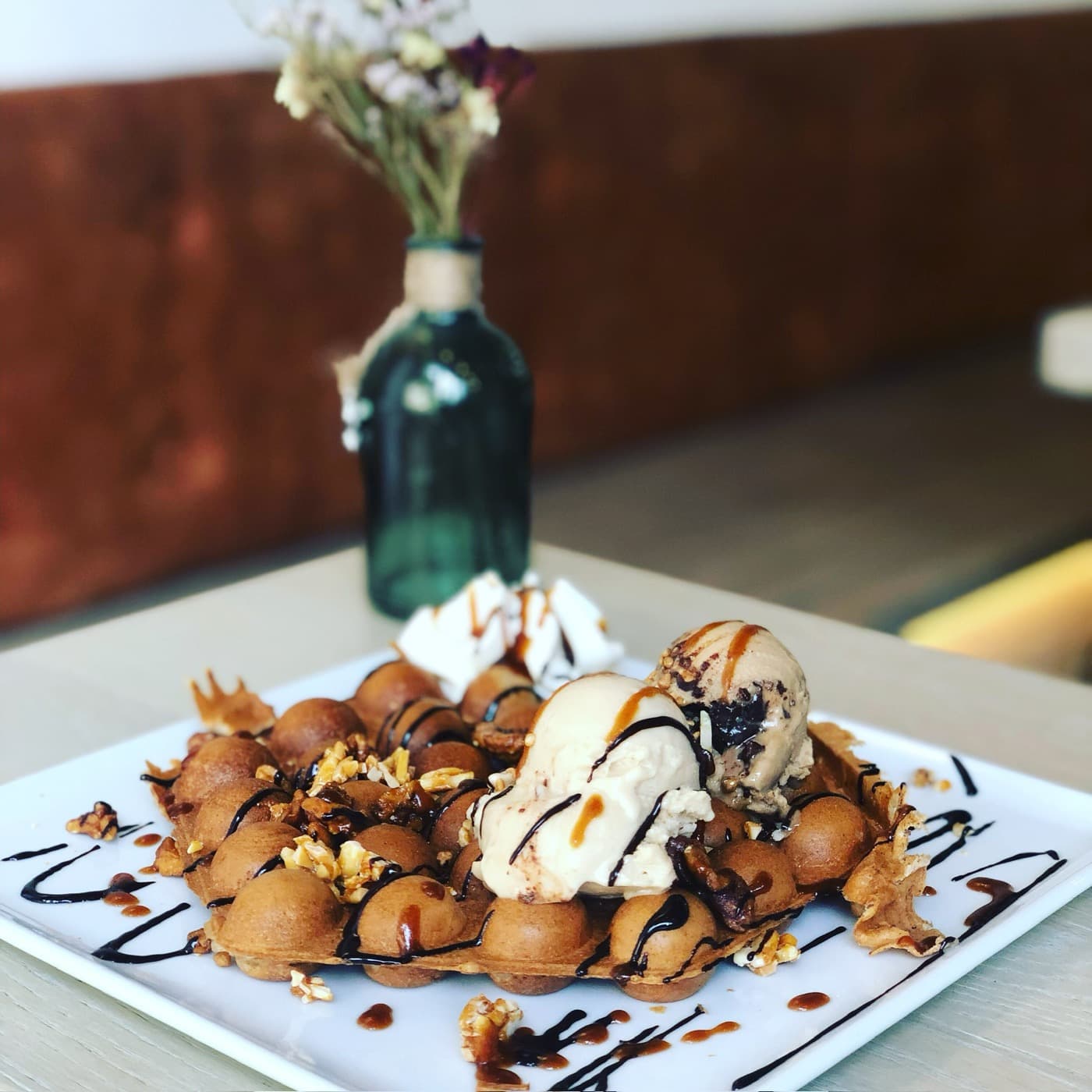 Bubble Waffle mit Eis, Karamell und Nüssen auf dem Teller