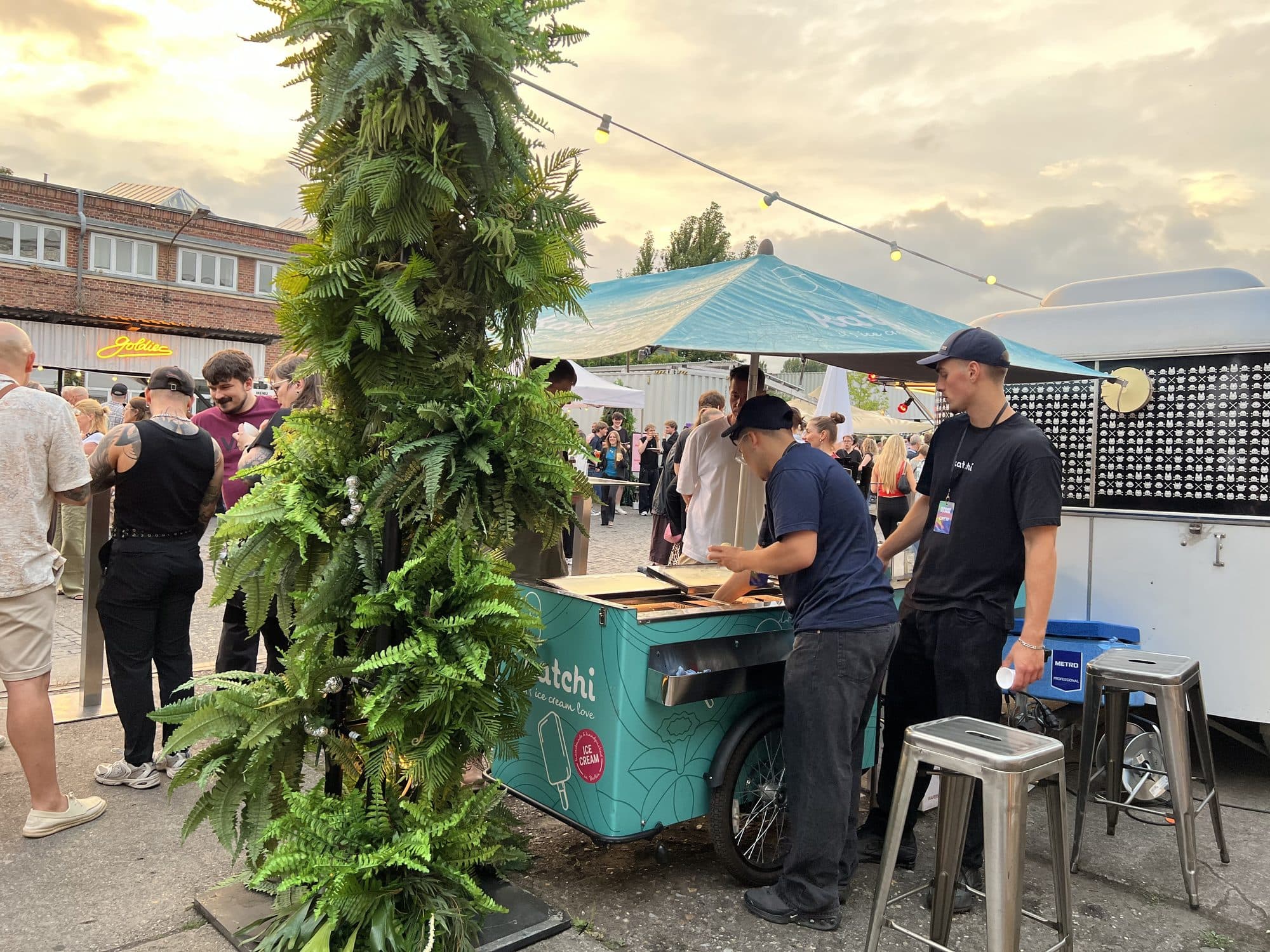 Katchi-Team in Katchi-Caps und -Shirts portioniert Eis am Ice Cream Bike beim Sommerfestival am Abend