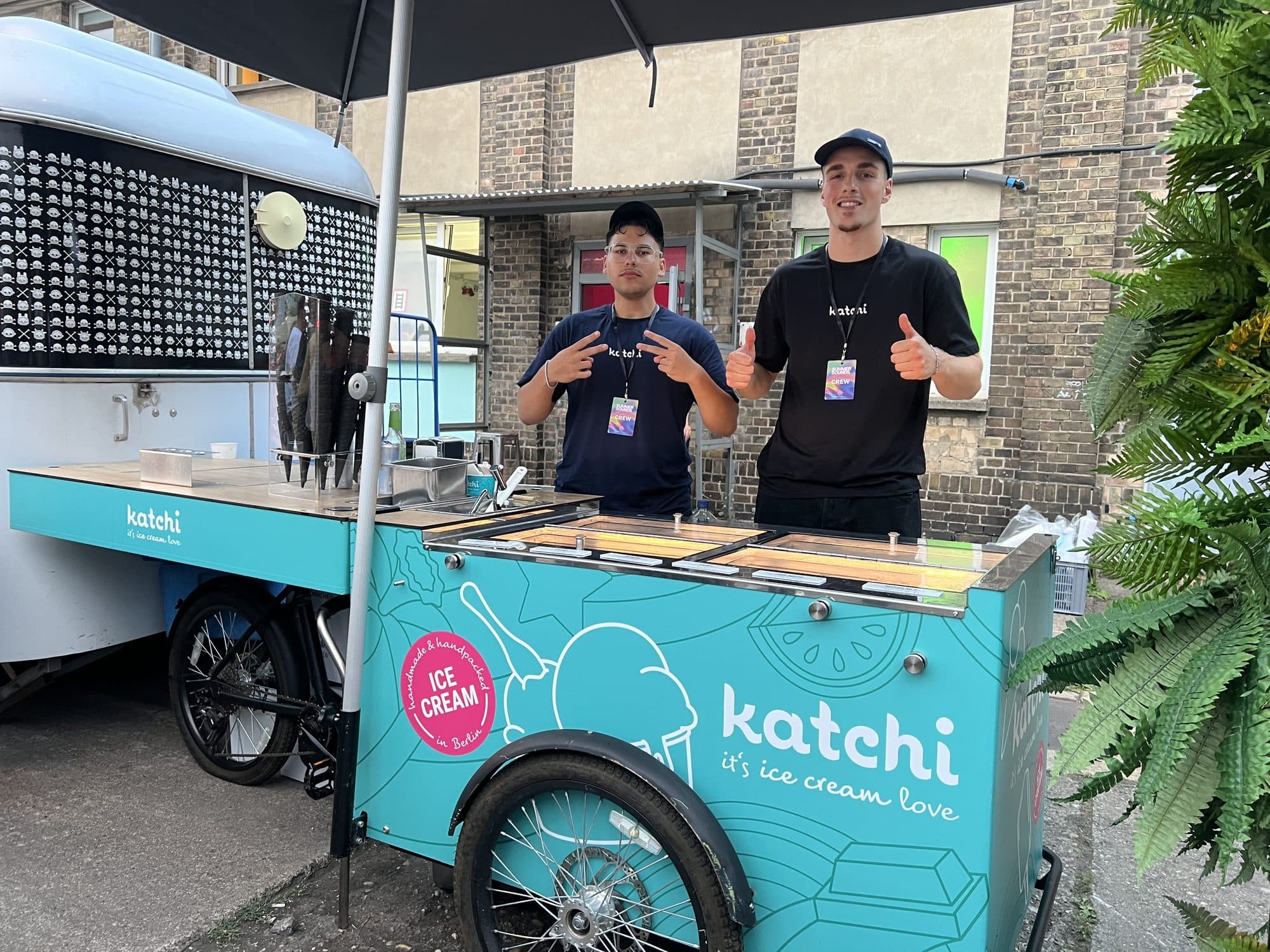 Zwei Katchi-Mitarbeiter mit Daumen hoch am Ice Cream Bike beim Outdoor-Event