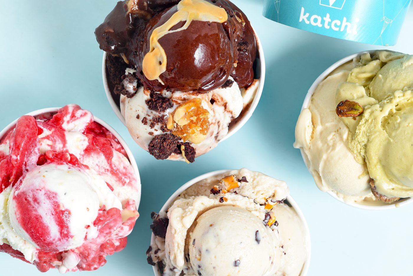 Vier Katchi-Becher von oben: Willy Wonka mit Brownie und Erdnusssauce, Erdbeere, Pistazie und Cookies