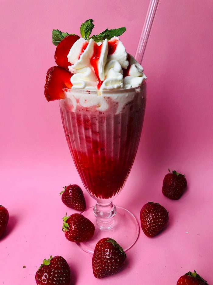 Ein frischer Erdbeermilkshake mit Sahne, Erdbeersoße und frischen Erdbeeren, gemacht vom Eiscafé Katchi Ice Cream in Berlin