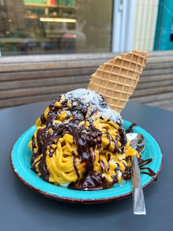 Laktosefreies Eis: veganes Spaghettieis mit Mango, Schokosauce und Kokosraspeln