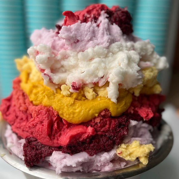 Bunte Eissorten in Rot, Gelb und Rosa übereinander geschichtet