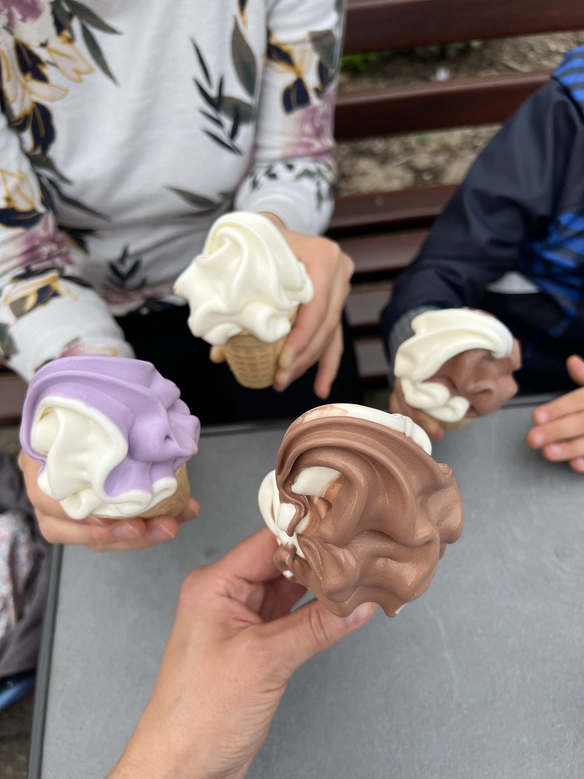 Vier Softeis in der Waffel – Vanille, Heidelbeere und Schoko-Vanille – am Tisch
