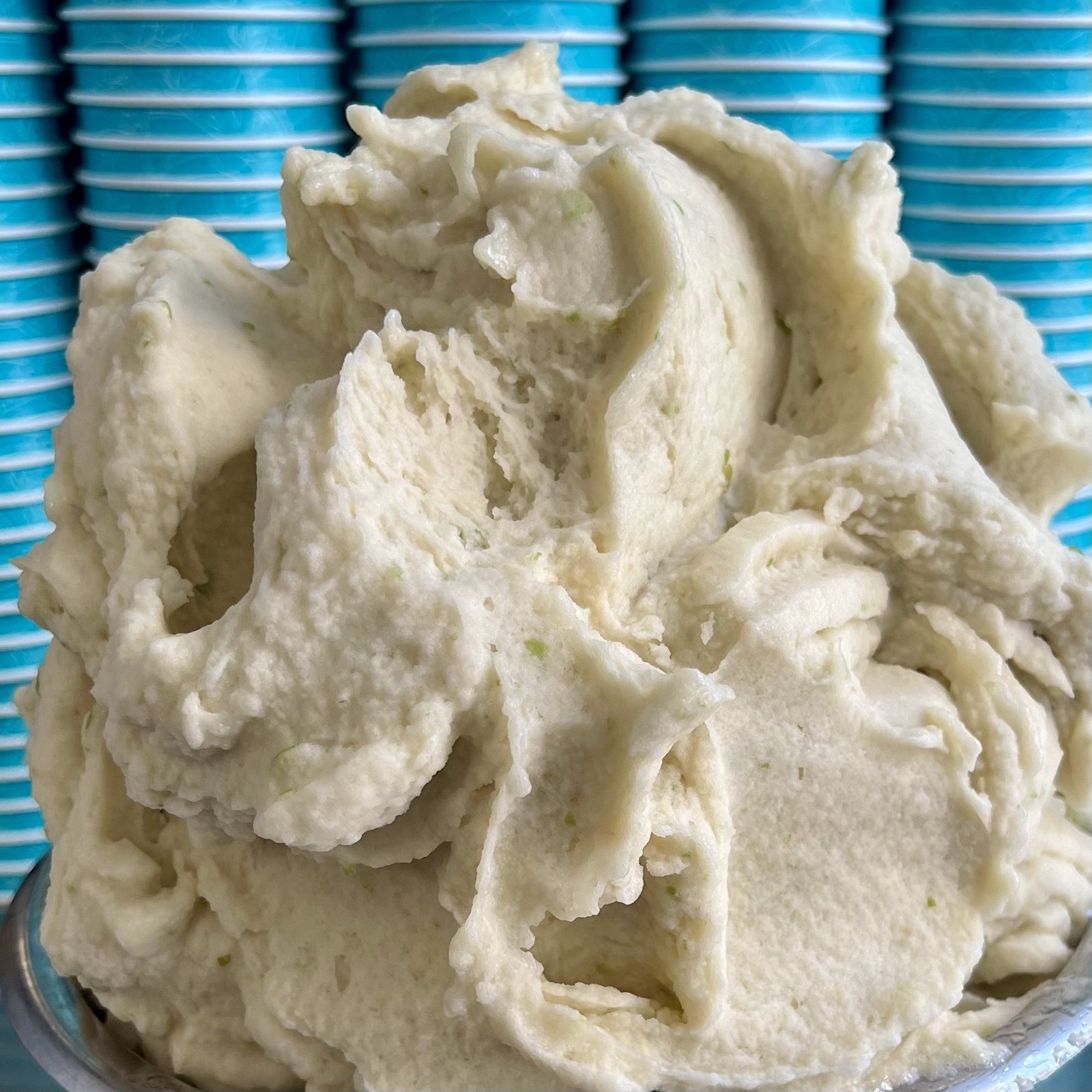 Birne-Basilikum-Sorbet von Katchi in der Eiswanne vor türkisen Bechern