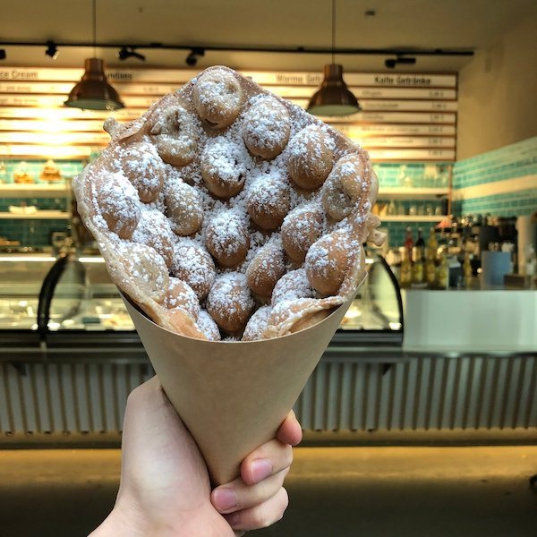 Bubble Waffle mit Puderzucker in der Tüte