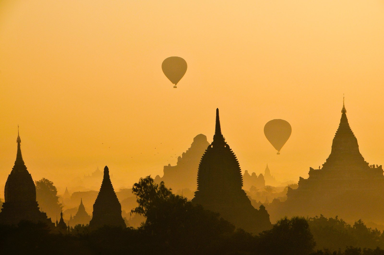 Tempel-Silhouetten und Heißluftballons im Sonnenaufgang
